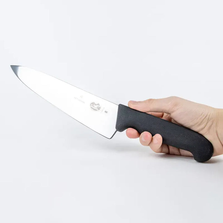 Victorinox Fibrox 5.2003.25 black 25cm carving knife held to show grip and scale