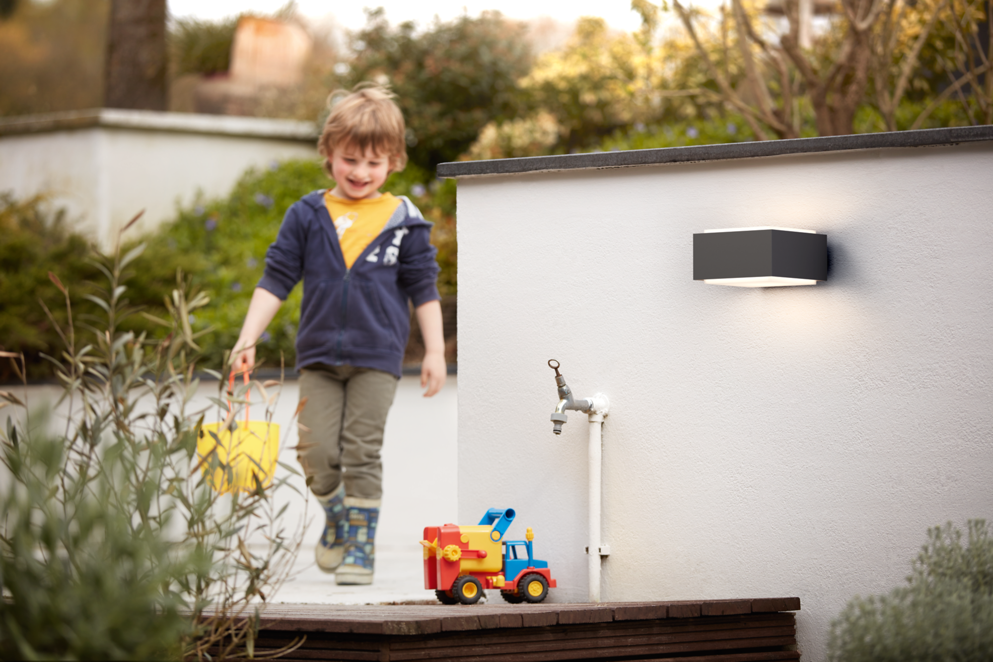 Philips Hedgehog outdoor wall light installed above a garden bench in daylight