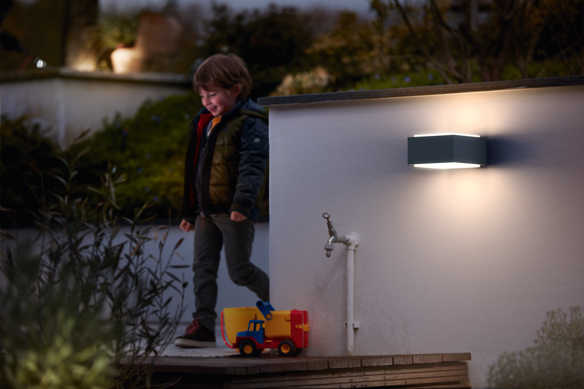 Philips Hedgehog outdoor wall light illuminating a garden bench at night