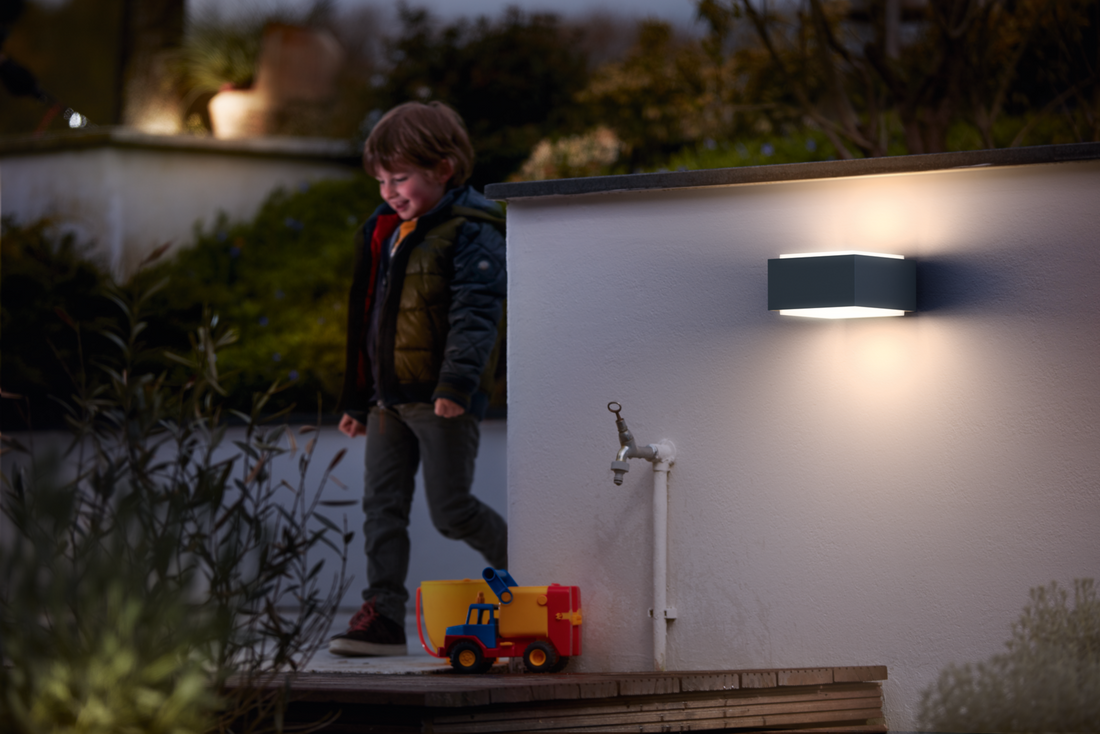 Philips Hedgehog outdoor wall light illuminating a garden bench at night